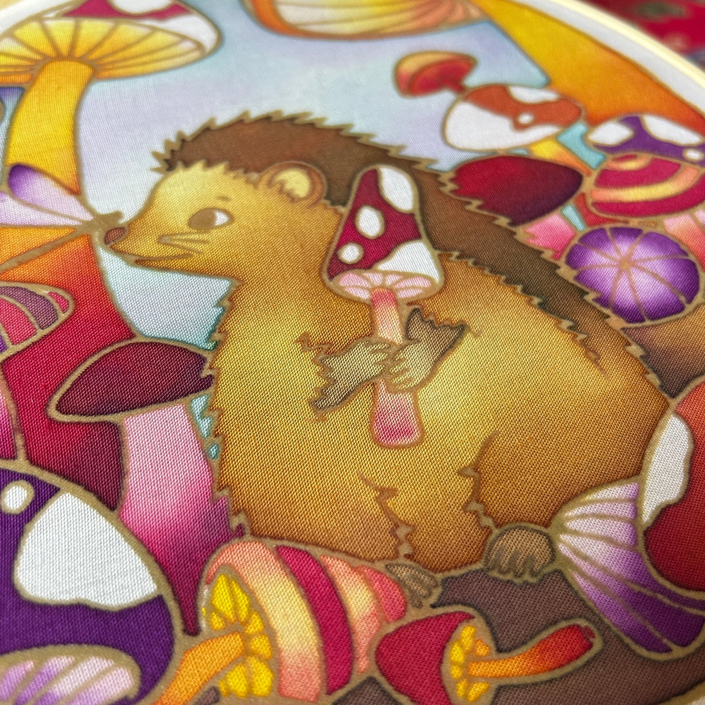 Down the Mushroom Hole batik craft kit displayed with finished hedgehog design in 20cm wooden ring