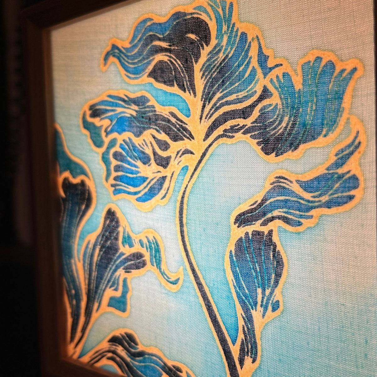 Batik Lamp Kit — Seasons in Colour. Completed lamp lit from inside, showing the botanical foliage design glowing in turquoise and gold through the cotton. By Batik Ying.