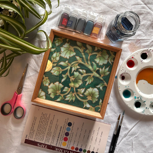 Completed Vintage Peonies batik art lamp glowing warmly on a wooden surface