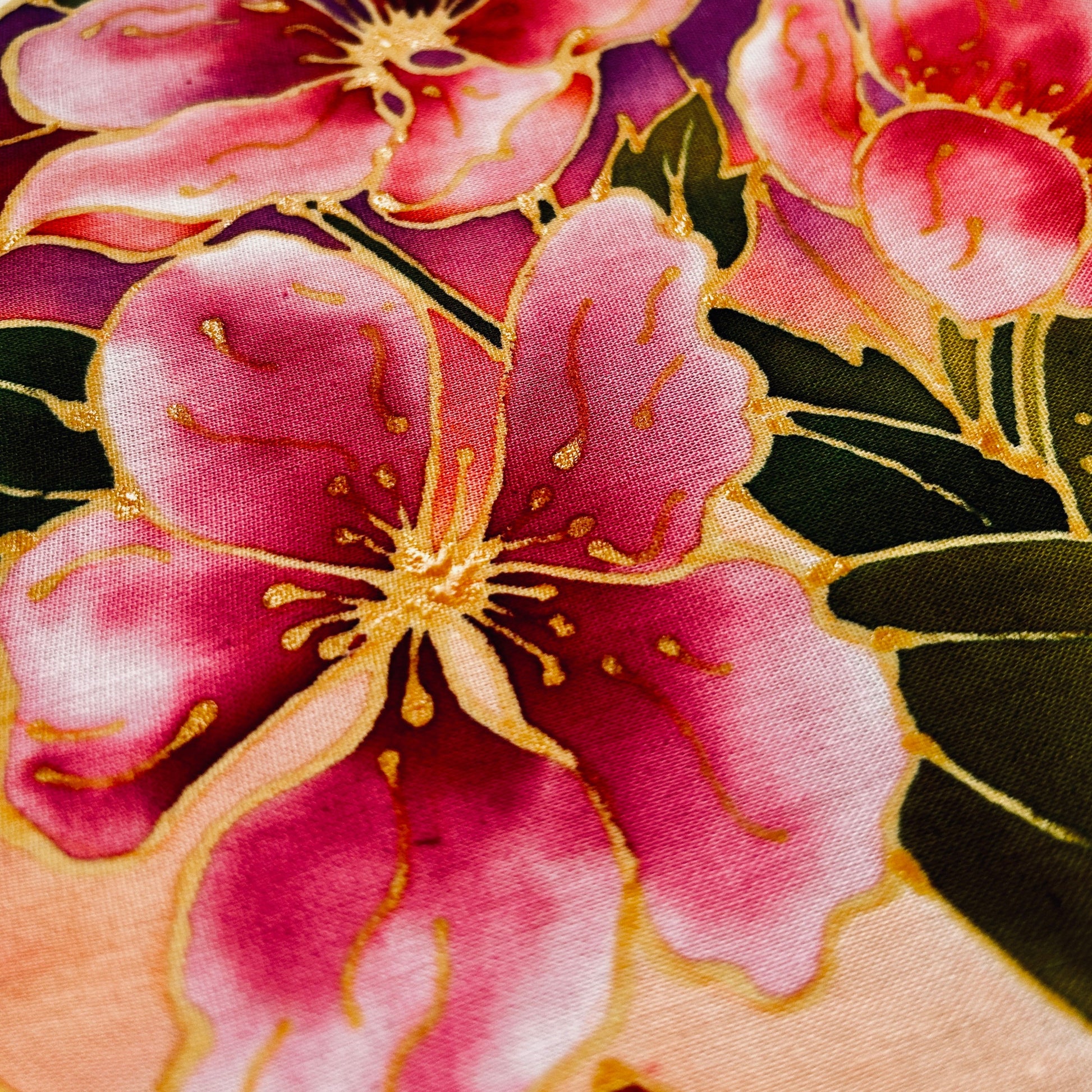 Close-up of vibrant pink and gold floral design on fabric from classic batik craft kit by Batik Ying