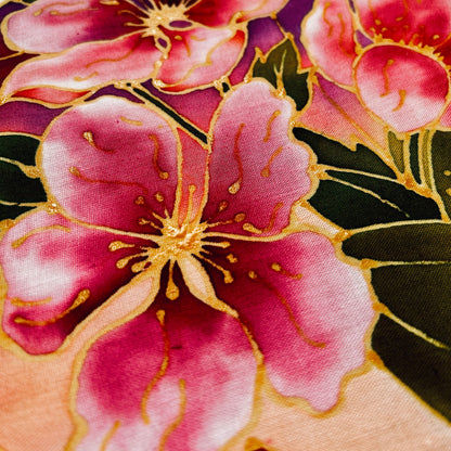 Close-up of vibrant pink and gold floral design on fabric from classic batik craft kit by Batik Ying