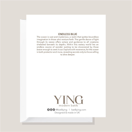 A white rectangular card or envelope with printed text, shown standing upright on a light gray surface against a warm beige background. The visible text includes the title 'ENDLESS BLUE' and branding at the bottom reading 'YING modern batik' with social details and 'Designed & made in UK'.